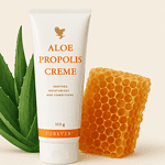 Eine Tube Aloe Propolis Creme steht aufrecht zwischen einem Aloe-Vera-Blatt und einer Honigwabe vor einem hellen Hintergrund.